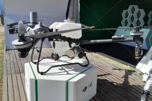 Opera con un motor por brazo y con hélices pivotantes para hacer un vuelo más estable. Descarga el material mediante un sinfín, lo que proporciona un flujo constante.